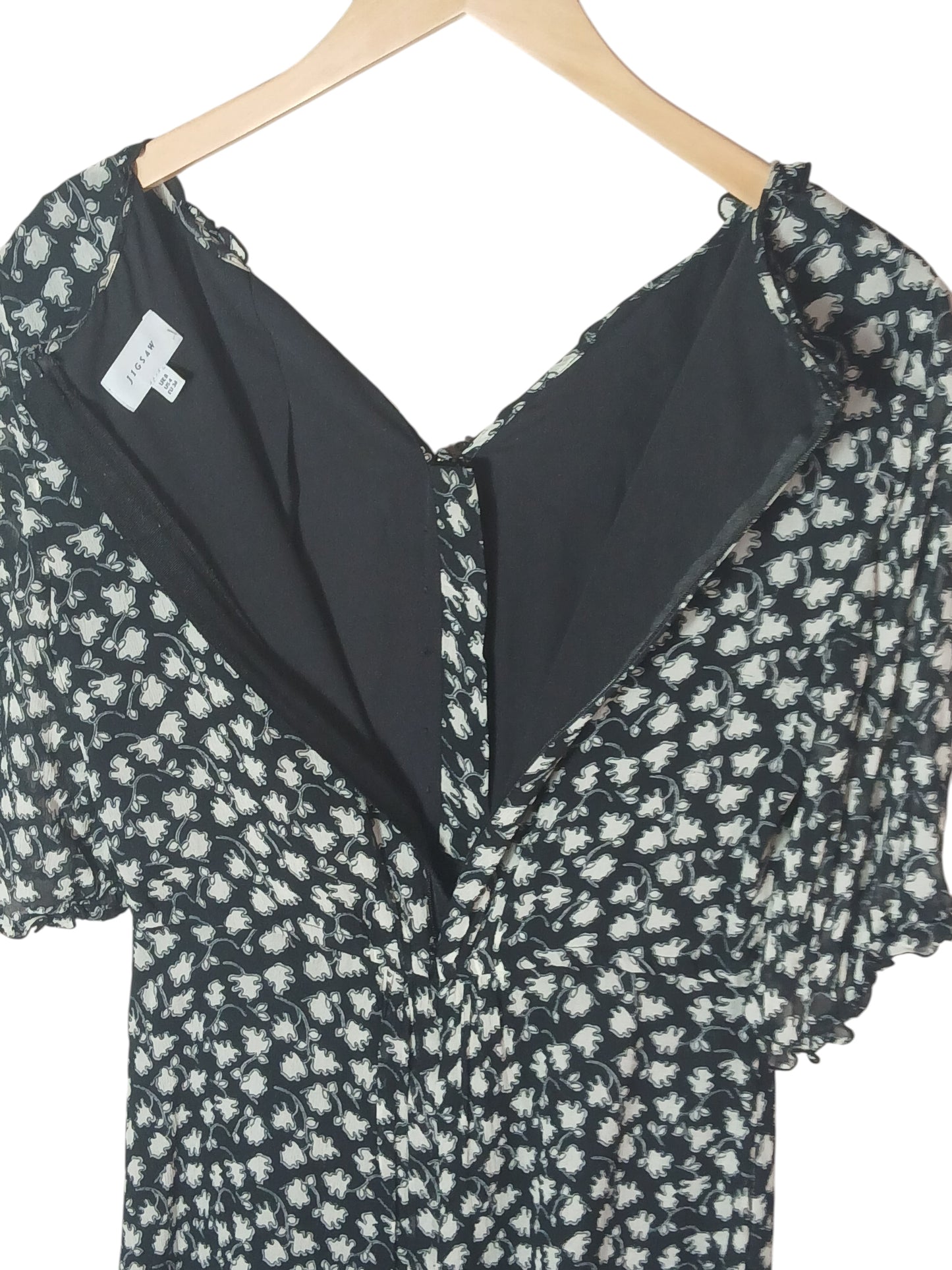 Department Store UK Jigsaw floral print dress with V-neck and back zipper closure on a wooden hanger