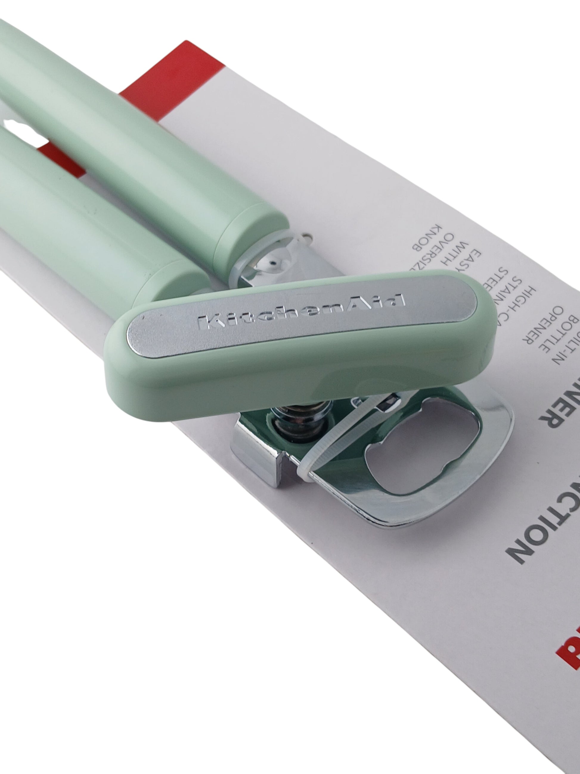 Department Store UK KitchenAid green multi-function can opener with stainless steel blade and oversized crank knob.