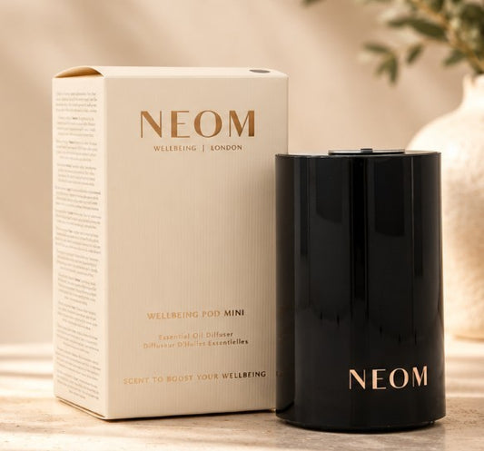 Department Store UK NEOM Wellbeing Pod Mini+ black waterless essential oil diffuser next to its original product box.